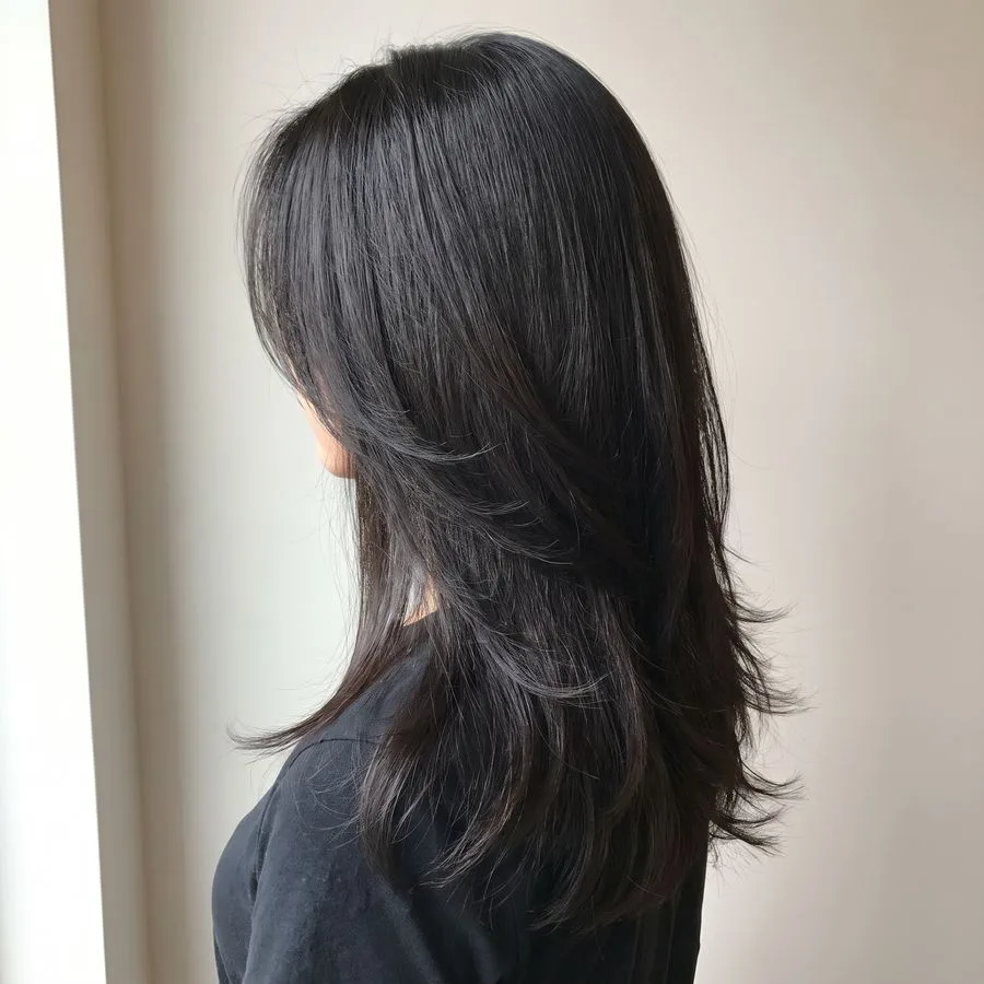 Long layers — dense hair past the collarbone with soft graduated layers through the mid-lengths and tapered ends
